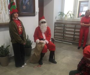 Uczniowie z Samorządu Uczniowskiego przebrani za Mikołaja i Elfa z workiem cukierków dla dzieci