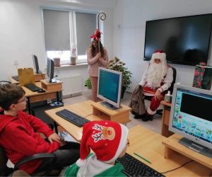 Mikołaj siedzi na krześle przed uczniami klasy IV