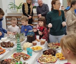 Inspektor oświaty i dyrektor szkoły stoją przed stołem z ciasteczkami