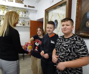 Pani Dyrektor rozdaje nagrody pocieszenia uczniom klasy siódmej