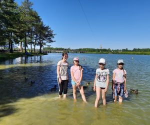 Cztery uczennice klasy V stoją po kolana w wodzie zalewu