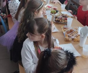 Dzieci z młodszej grupy podczas poczęstunku przy stole