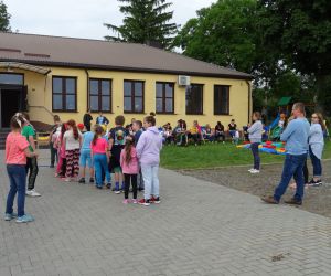 Dzieci stoją w rzędzie, biorą udział w zabawie