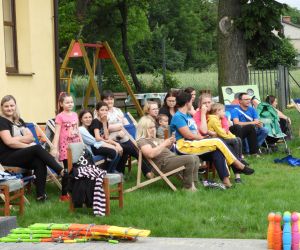 Dorośli siedzą na leżakach, rozmawiają ze sobą