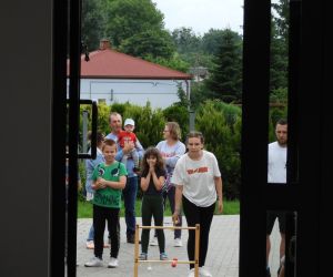 Przez otwarte drzwi widać, jak dzieci grają w grę na placu