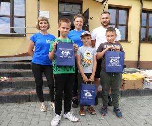 Uśmiechnięte dzieci pozują do zdjęcia, w rękach trzymają nagrody