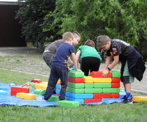 Grupa dzieci bawi się dużymi klockami
