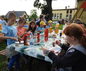 Dzieci siedzą przy stole, jedzą