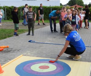 Instruktorka tłumaczy zasady gry, dzieci słuchają