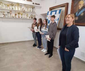 Nauczycielka języka polskiego i uczniowie klasy ósmej na głównym korytarzu szkoły