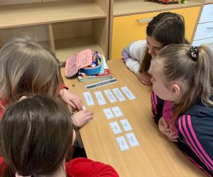 Uczennice układają karteczki z zagadką językową