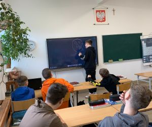 Uczeń rysuje na tablicy, uczniowie obserwują