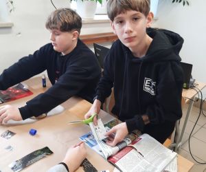 Dwaj uczniowie pracujący nad projektem przedstawiającym zawód żołnierza