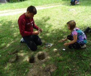 Dzieci znajdują się na świeżym powietrzu, rozpalają ogień.