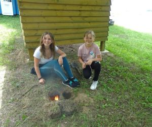 Dzieci znajdują się na świeżym powietrzu, rozpalają ogień.