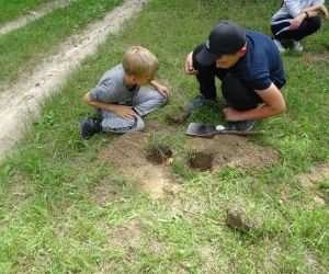 Dzieci znajdują się na świeżym powietrzu, rozpalają ogień.