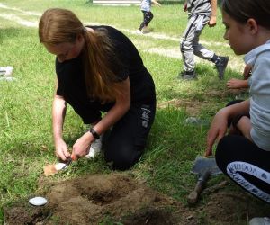 Dzieci znajdują się na świeżym powietrzu, rozpalają ogień.