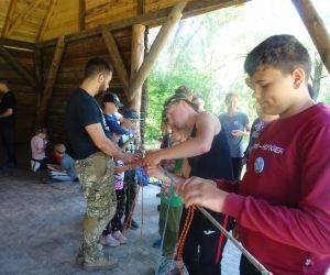 Dzieci na świeżym powietrzu uczą się wiązać węzły. 