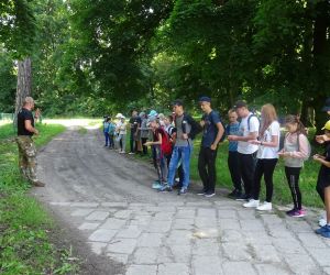Dzieci na świeżym powietrzu uczą się zastosowania kompasu.