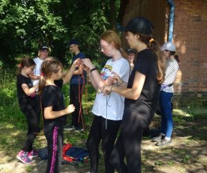 Dzieci znajdują się na świeżym powietrzu, uczą się wiązania węzłów.