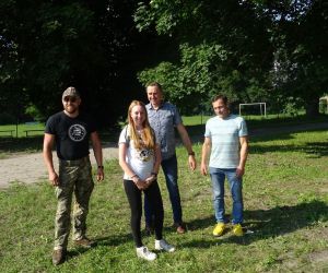 Uczestnik spotkania odbiera nagrodę, która wręcza Wójt Gminy Hrubieszów, radny oraz prowadzący survival.