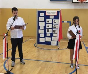 Dwoje uczniów stoi przy mikrofonach