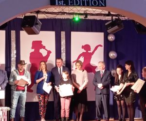 Uczestnik z organizatorami na scenie