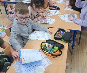 Uczniowie rozwiązują zadania na kartach pracy