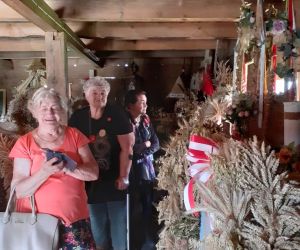 Zdjęcie przedstawia dorosły osoby wewnątrz Muzeum Wieńców Dożynkowych.