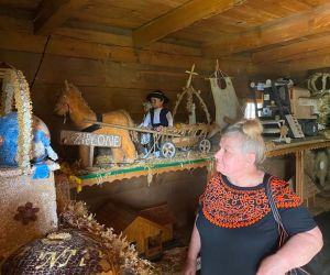 Zdjęcie przedstawia dorosłą osobę wewnątrz Muzeum Wieńców Dożynkowych.