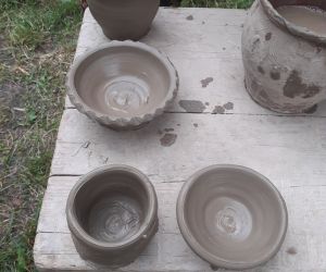 Zdjęcie przedstawia garnki wykonane z gliny.