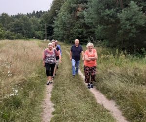 Zdjęcie przedstawia osoby dorosłe idące drogą polną.