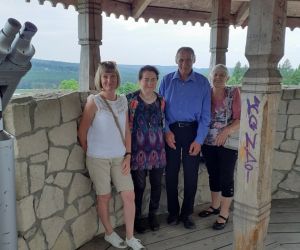 Zdjęcie przedstawia grupę ludzi na świeżym powietrzu stojących na wieży widokowej.