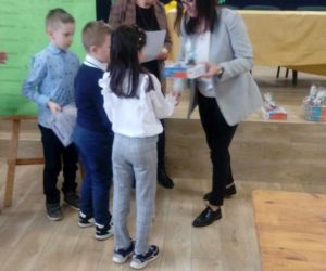 Troje uczniów odbiera nagrodę konkursową od pań organizatorek