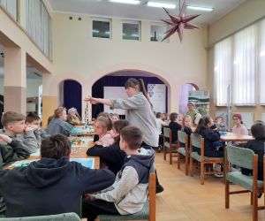 Prowadząca warsztaty prezentuje naszyjnik ze szklanymi paciorkami