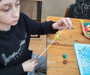 Chłopiec wykonuje paciorek z modeliny