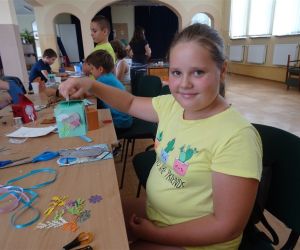 Zdjęcie przedstawia dzieci prezentujące pudełka na skarby, które wykonały samodzielnie podczas warsztatów.