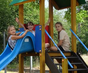 Zdjęcie przedstawia dzieci bawiące się na placu zabaw.