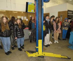 Uczniowie z opiekunami w warsztacie naprawy aut