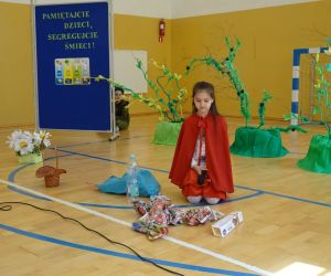 Uczennica - Czerwony Kapturek siedzi przy kupce śmieci