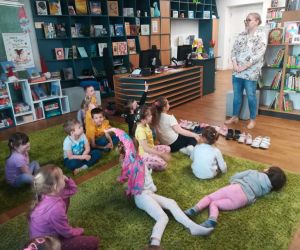 Pani tłumaczy przedszkolakom zasady korzystania z biblioteki miejskiej