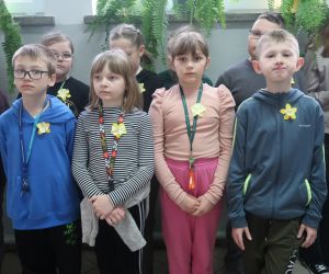 Uczniowie z przypiętymi żonkilami pozujący do zdjęcia