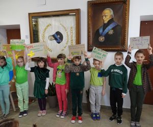 Uczniowie klasy drugiej trzymają w rękach plakaty proekologiczne wykonane z okazji Dnia Ziemi