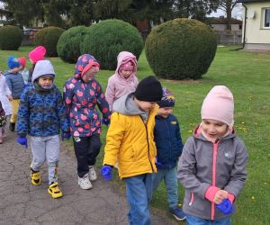 Dzieci zbierają śmieci wokół przedszkola.