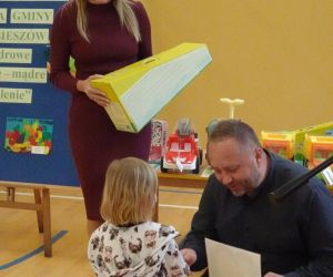 Pan inspektor i pani dyrektor wręczają nagrodę dziewczynce