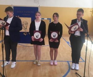 Uczniowie klasy siódmej - dwóch chłopców i dwie dziewczynki przy mikrofonach