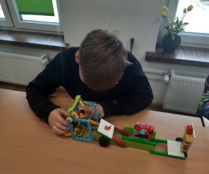 Uczeń z budowlą z klocków