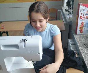 Uczennica zszywa materiał