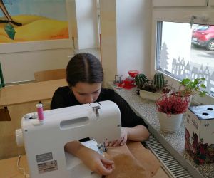 Dziewczynka zszywa materiałowe serce