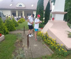 Dwaj uczniowie zapalają znicz przy pomniku związanym ze Stanisławem Staszicem w Dziekanowie